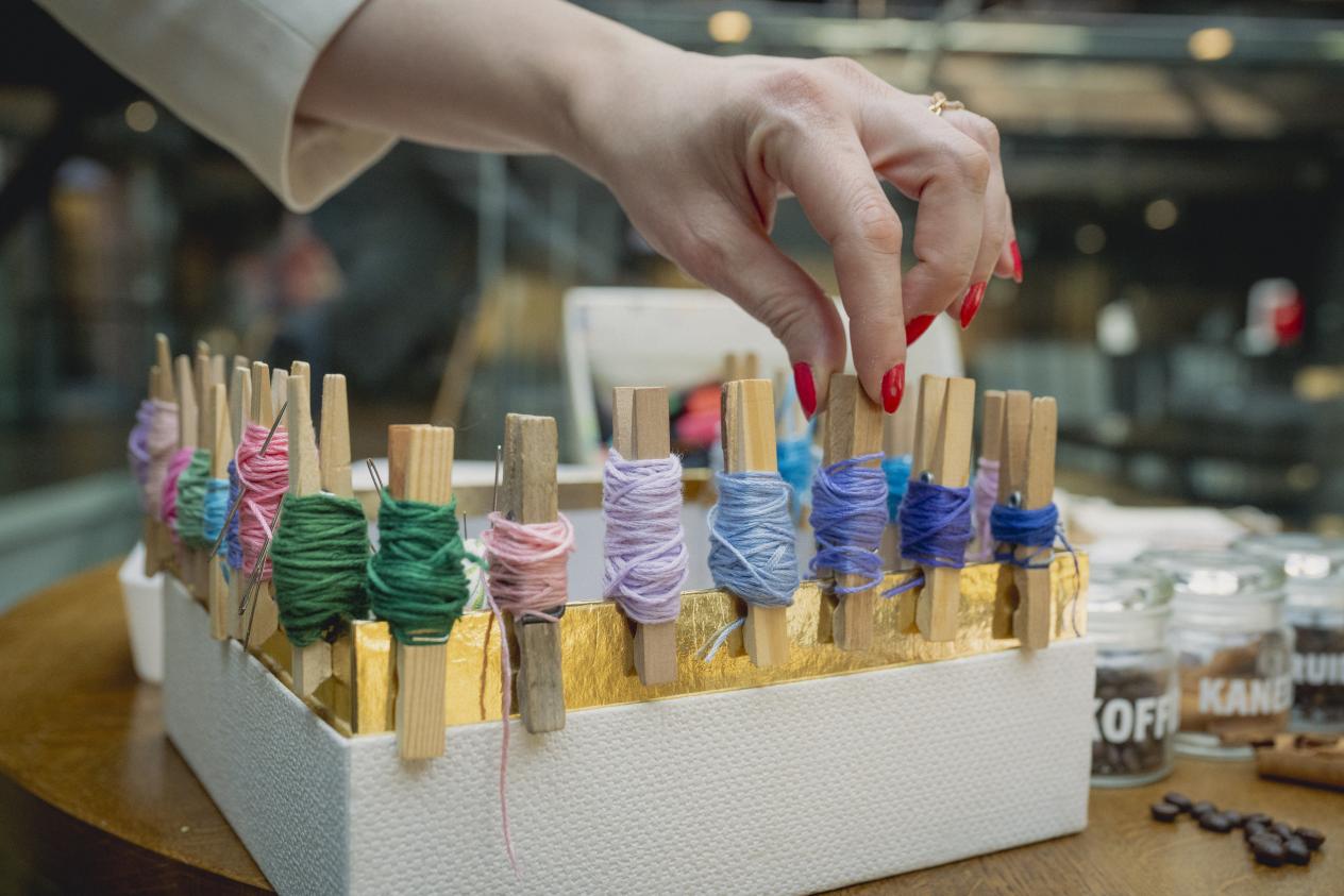 Een hand grijpt naar naaigaren