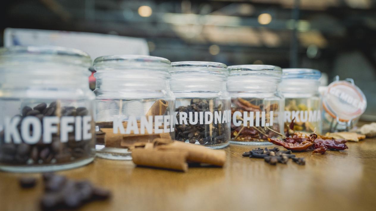 Een reeks glazen potjes met kruiden 