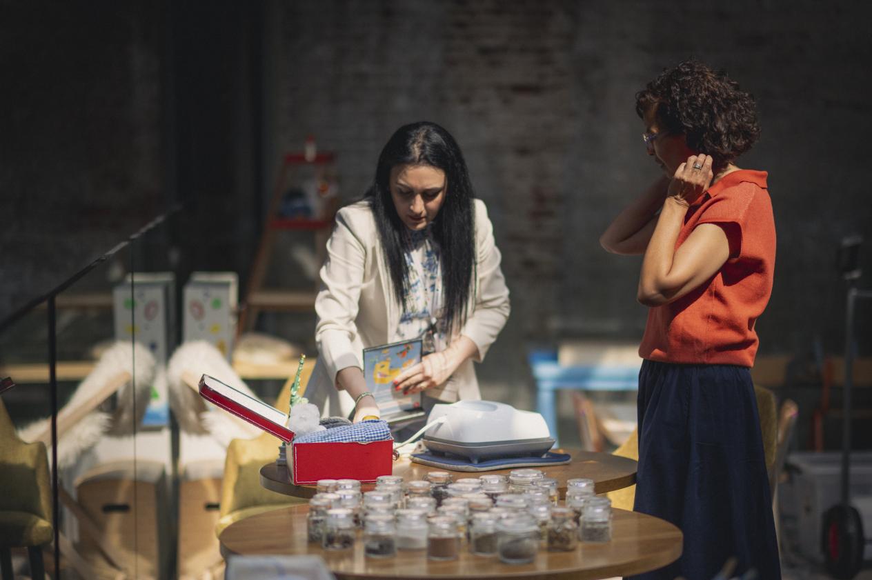 Twee vrouwen staan aan een tafeltje