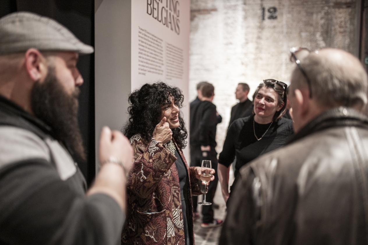 Een vrouw praat tegen een groep mensen in het museum