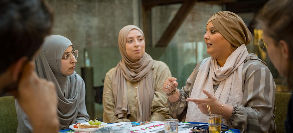 Een groep vrouwen in gesprek aan tafel