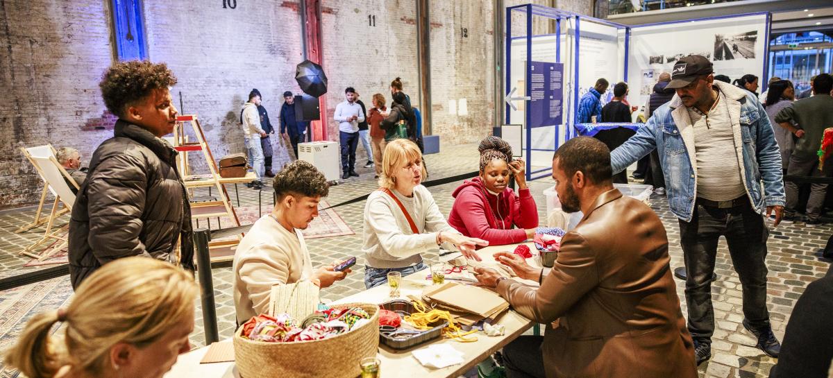 Een groep mensen aan een tafel knutselt