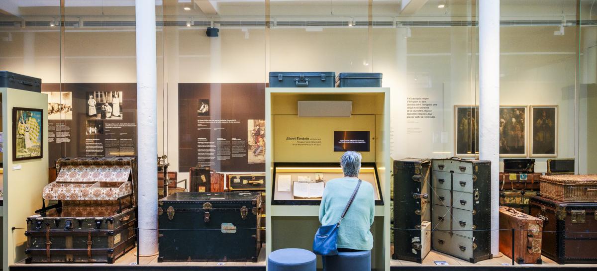 Een dame zit op een stoel in een museumzaal