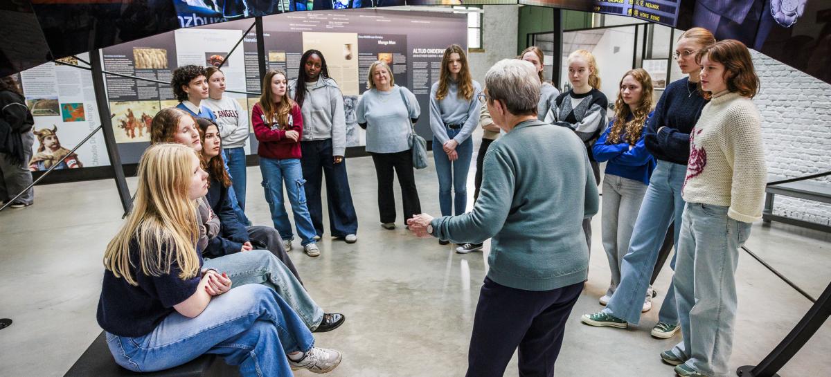 Een klas in het museum luistert naar de gids