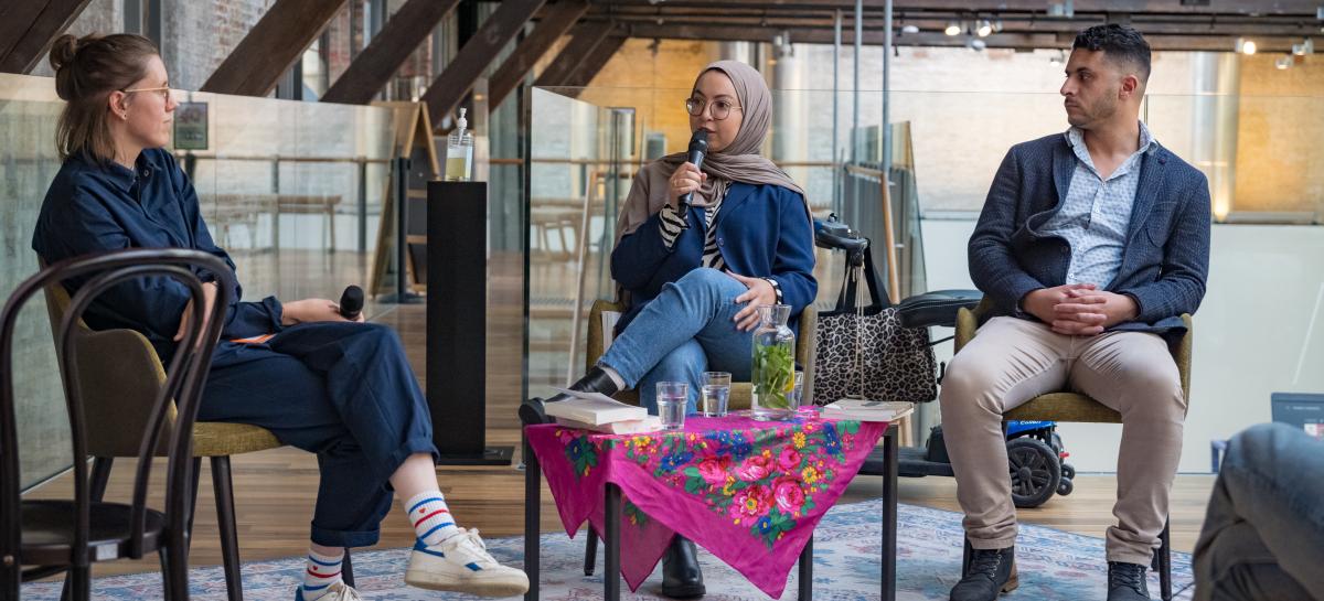 Drie personen praten in een panelgesprek 