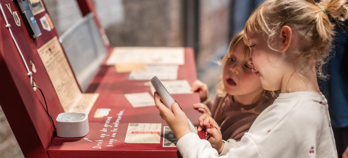 Twee meisjes bekijken kaartjes in een expo