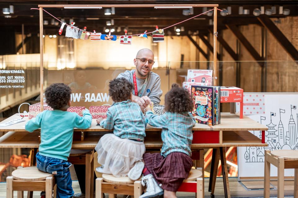 Drie kinderen en een volwassene knutselen aan een tafel