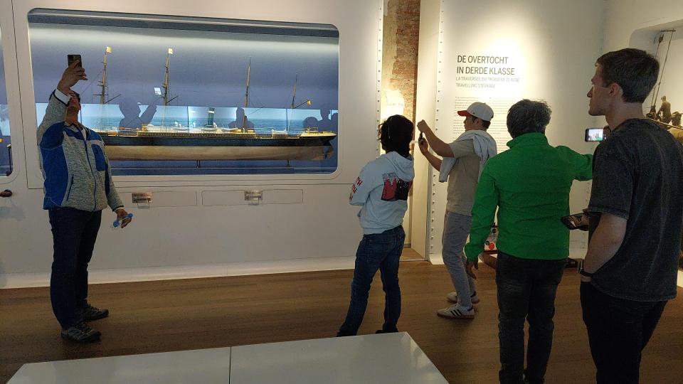 Een groep mensen luistert in een museum naar een gids