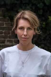 Portretfoto van een vrouw met bruine haren en een wit T-shirt