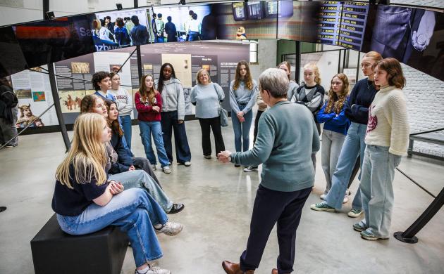 Een klas in het museum luistert naar de gids