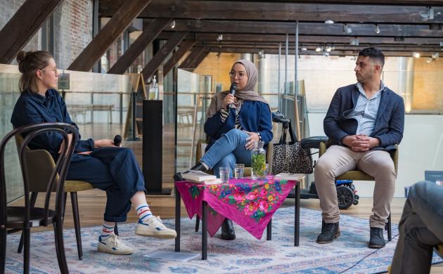 Drie personen praten in een panelgesprek 
