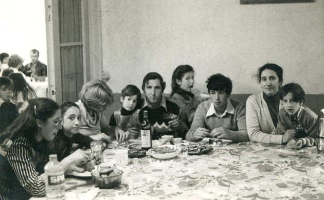 Een familie zit rond een eettafel
