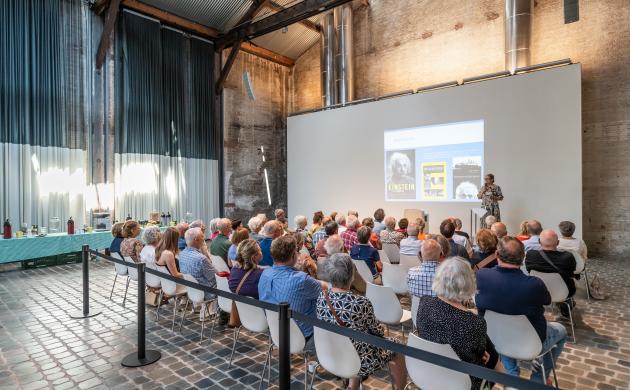 Een groep mensen luistert naar een spreker