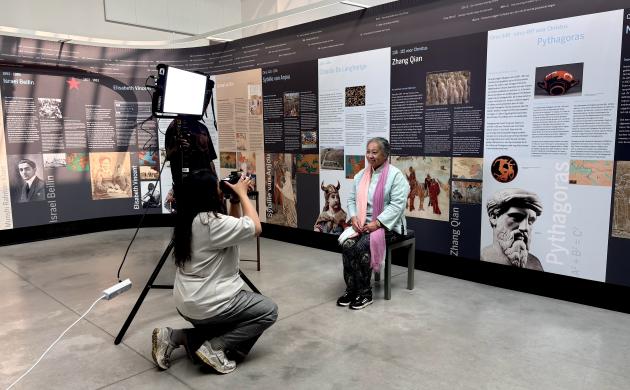 Een fotograaf neemt foto's van een persoon in een museumzaal