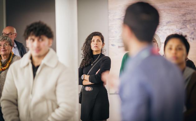 Mensen in een museumzaal luisteren naar de gids