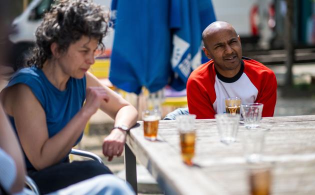 twee mensen praten met elkaar aan een tafel