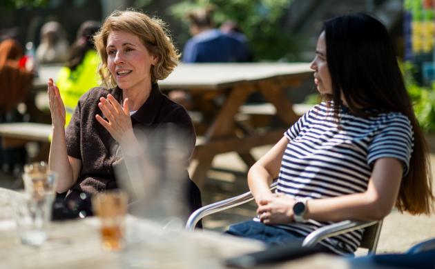 twee mensen praten met elkaar aan een tafel