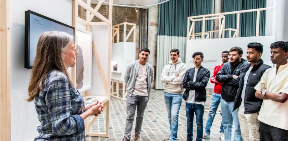 leerlingen volgen een rondleiding in de expo Vluchtverhalen