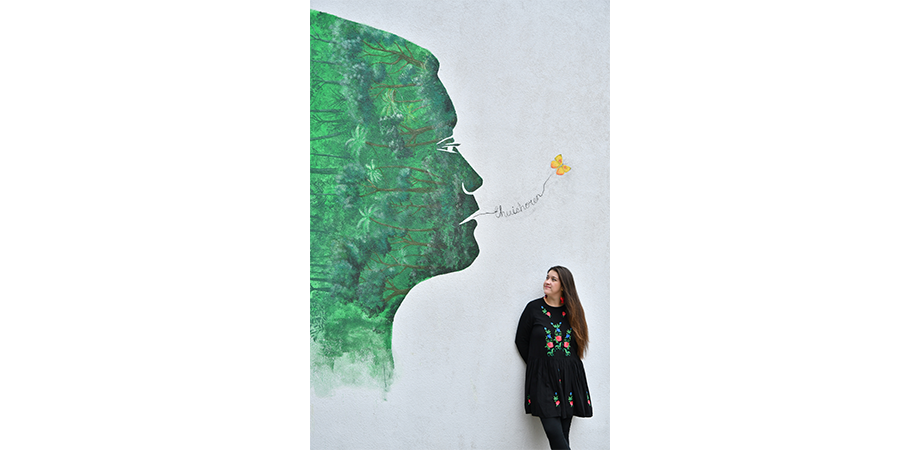 Laura Vargas devant son mural à la bibliothèque Permeke.