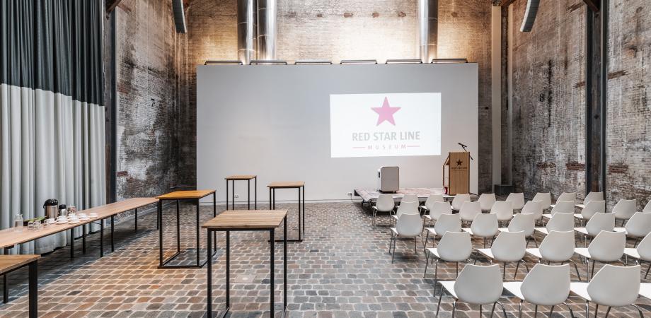 De museumloods in een opstelling met stoelen, tafels en presentatiescherm