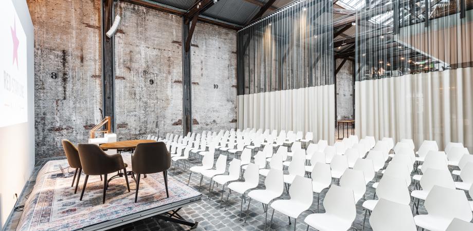 opstelling in de loods van stoelen en een podium met spreekgestoelte