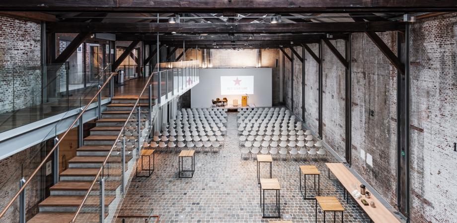 De lege loods van het museum met enkele tafels