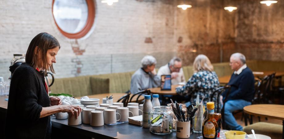 foto van een bar met mensen aan een tafeltje op de achtergrond