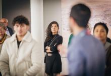 Mensen in een museumzaal luisteren naar de gids